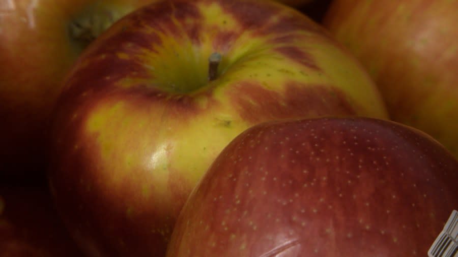 Different kinds of apples are avaiable for purchase which several customers purchased.