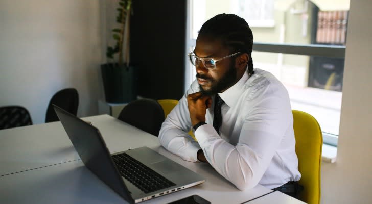 A margin trader looks over his account on his laptop. 