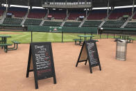 FILE - In this May 27, 2020, file photo, menu boards and tables occupy the third base infield dirt in preparation for dining guests at McCoy Stadium, home of the Pawtucket Red Sox, in Pawtucket, R.I. Following a year without a season due to the coronavirus pandemic, thousands of minor league players are finally returning to work. (AP Photo/Jimmy Golen, File)