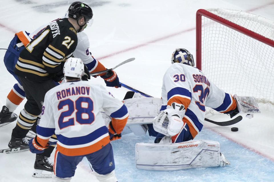 New York Islanders goaltender Ilya Sorokin (30) is unable to stop a goal by Boston Bruins right wing David Pastrnak, not shown, as defenseman Alexander Romanov (28) defends in front of Bruins left wing James van Riemsdyk (21) in the third period of an NHL hockey game, Thursday, Nov. 9, 2023, in Boston. (AP Photo/Steven Senne)