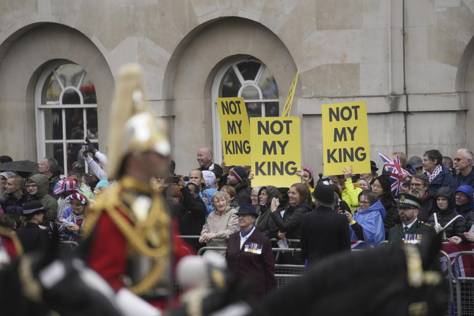 La procesión que acompaña al rey Carlos III y la reina Camila rumbo al Palacio de Buckingham pasa frente a personas que se oponen a la monarquía en Londres, el sábado 6 de mayo de 2023. (AP Foto/Mosa'ab Elshamy)