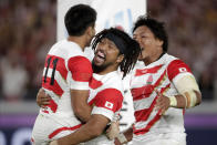 Japan's Kenki Fukuoka (11) celebrates with Shota Horie after scoring a try during the Rugby World Cup Pool A game at International Stadium against Scotland in Yokohama, Japan, Sunday, Oct. 13, 2019. (AP Photo/Jae Hong)