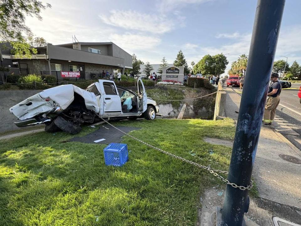 A Dodge is chained from falling into Chicken Ranch Slough following a crash Saturday, May 18, 2024, on Fulton Avenue in the Arden Arcade section of Sacramento County. The driver of the pickup truck was killed and another motorist was arrested on suspicion of DUI.