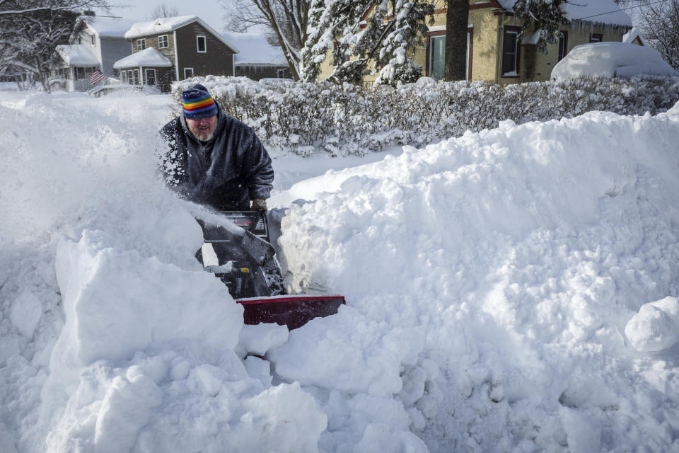Pat Lundquist works at clearing the sidewalk all the way to the street Sunday, Feb. 24, 2019, near his house in Rochester, Minn., after heavy snow overnight. ( Joe Ahlquist/The Rochester Post-Bulletin via AP)