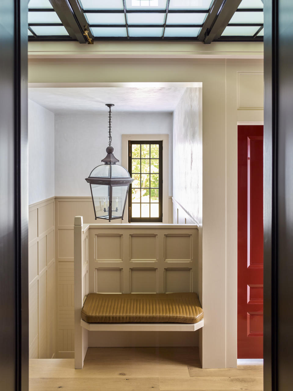 A built-in bench at the top of the steps, surrounded y wainscoting, creates a seating area out of unused space.