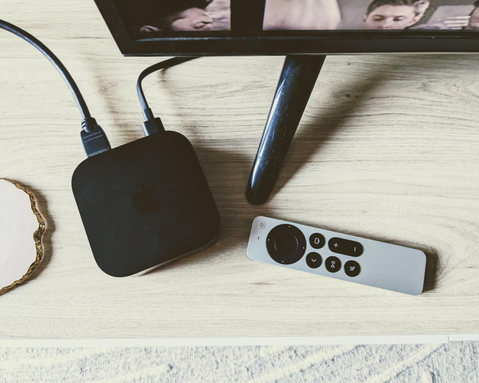 Apple TV 4K and remote viewed from above on TV unit in writer's home