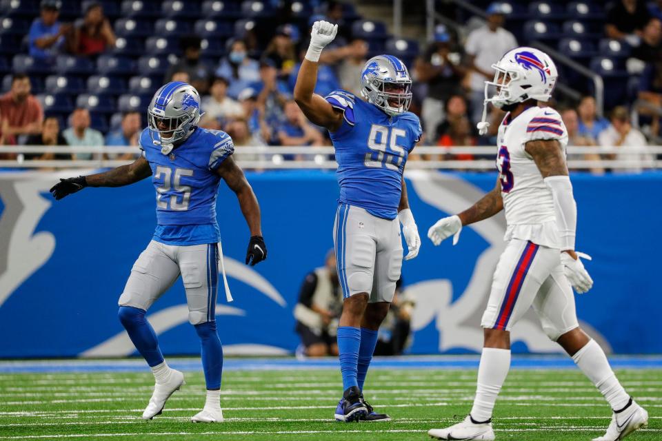 Detroit Lions defensive end Romeo Okwara (95) and  defensive back Will Harris (25) celebrate a play against the Buffalo Bills during the second half of the preseason game at Ford Field in Detroit on Friday, Aug. 13, 2021.