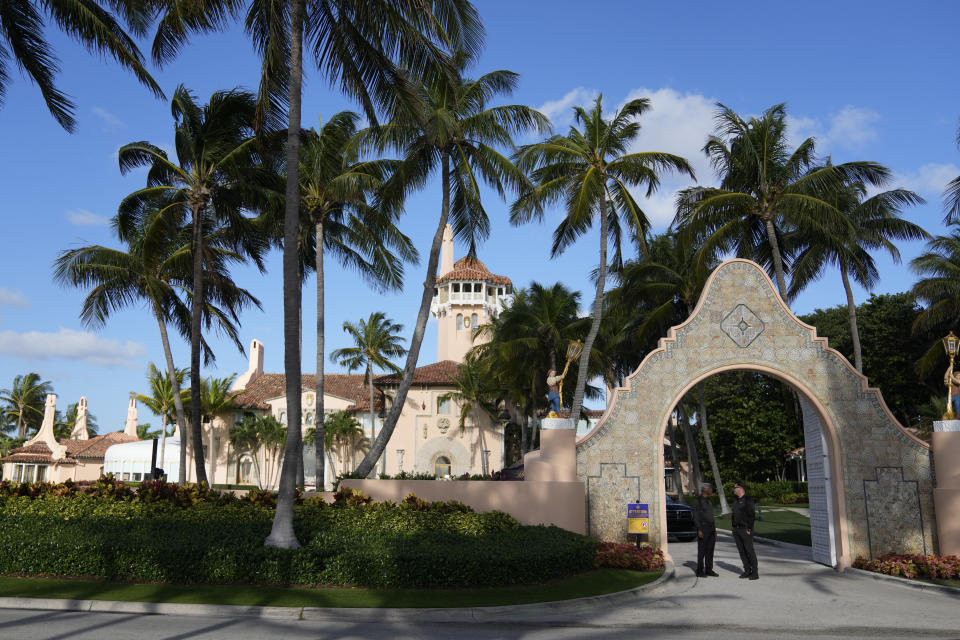 Two security agents talk to each other at the entrance to Trump’s Mar-a-Lago estate.