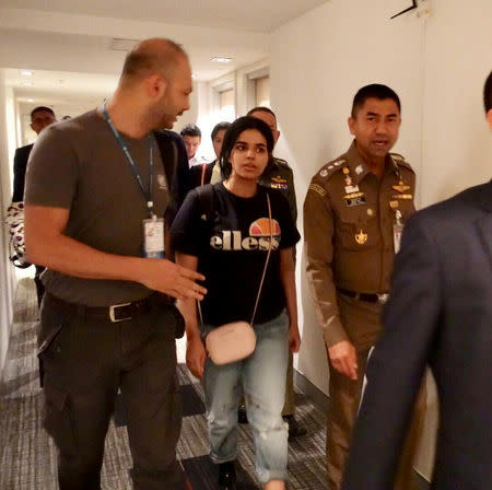 Saudi teen Rahaf Mohammed al-Qunun walks with Thai immigration authorities at a hotel inside Suvarnabhumi Airport in Bangkok, Thailand January 7, 2019. Thailand Immigration Police via REUTERS