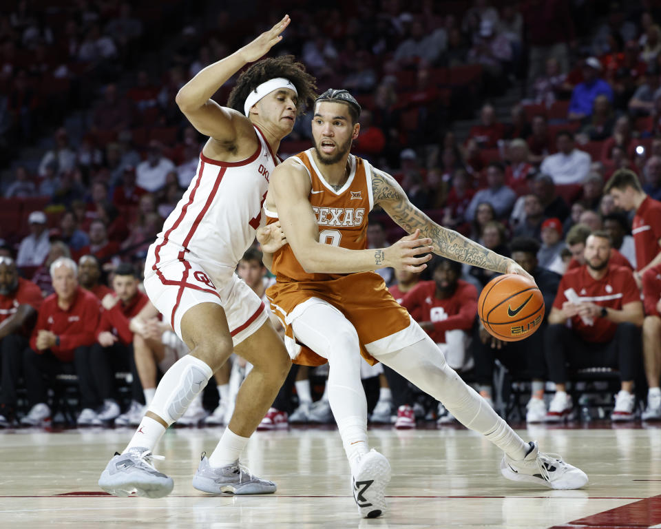 Texas forward Timmy Allen, right, goes against Oklahoma forward Jalen Hill (1) during the first half of an NCAA college basketball game Saturday, Dec. 31, 2022, in Norman, Okla. (AP Photo/Garett Fisbeck)