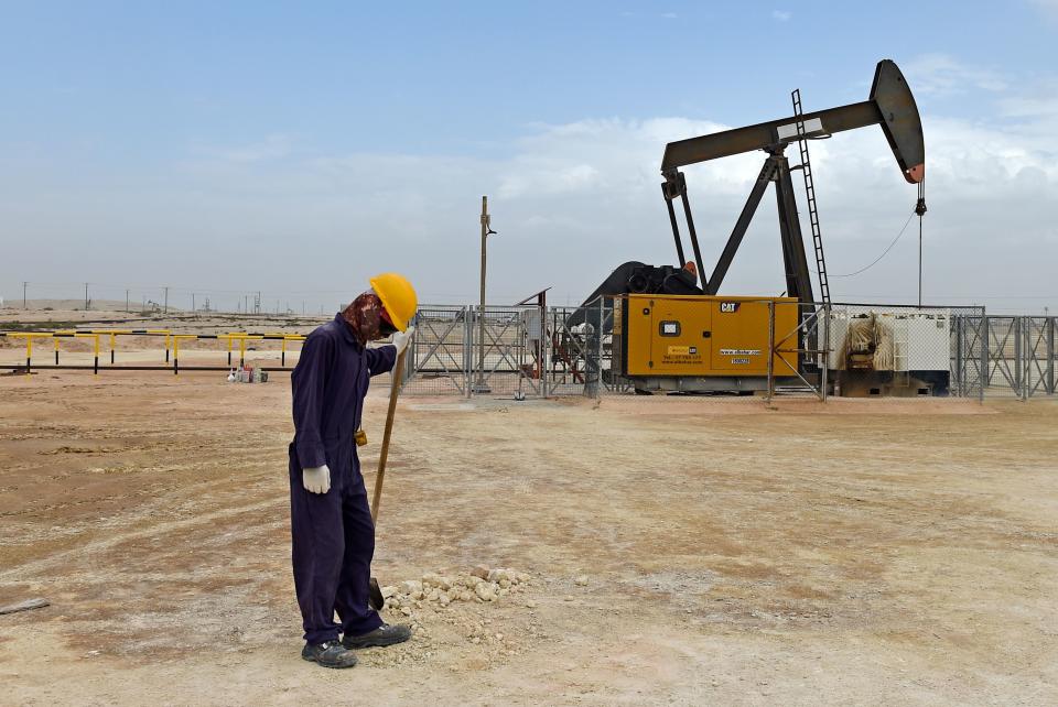 A worker stands across a pumpjack operating in the desert oil fields of Sakhir in southern Bahrain on April 22, 2020. (Photo by Mazen Mahdi / AFP) (Photo by MAZEN MAHDI/AFP via Getty Images)