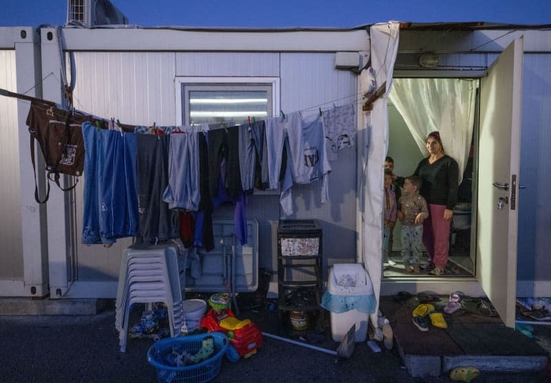 A woman stands with her children in the doorway of a container home near Kahramanmaras, where she and her family were housed after the 7.8-magnitude earthquake that struck southern Turkey and northern Syria on 06 February 2023. Boris Roessler/dpa