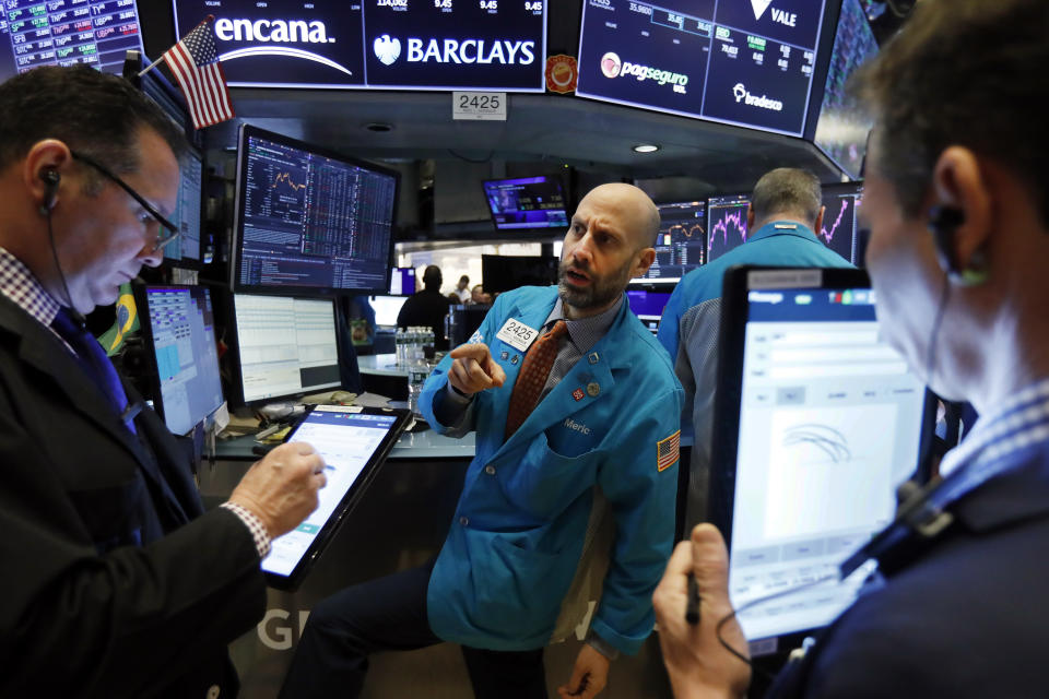 FILE - In this Jan. 10, 2020, file photo specialist Meric Greenbaum, center, works at his post on the floor of the New York Stock Exchange. The U.S. stock market opens at 9:30 a.m. EST on Thursday, Jan. 16. (AP Photo/Richard Drew, File)