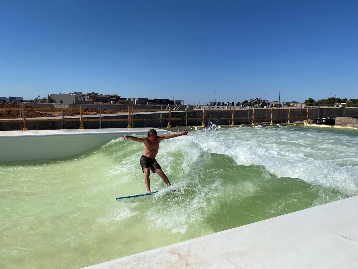 Prestin Hartle, who is opening a business at Cannon Beach in Mesa, rides a wave in the UNIT Surf Pool.