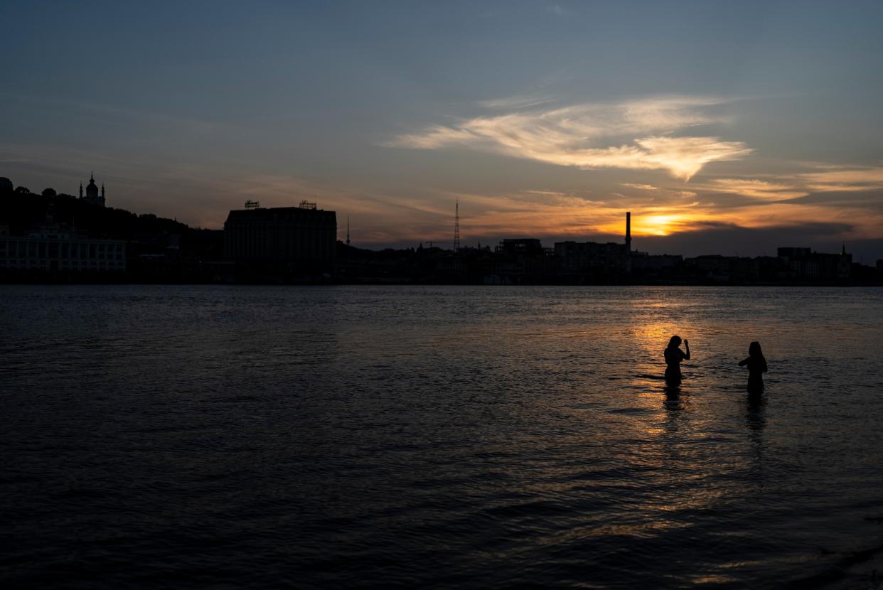 Two women cool off in the Dnieper river in Kyiv (AP)