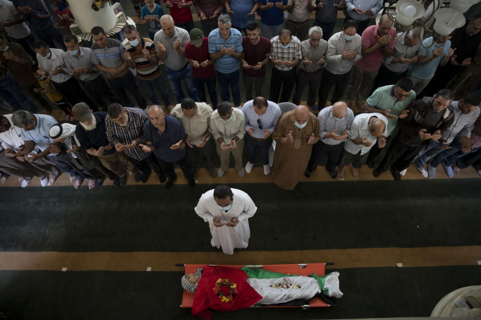 Palestinian mourners pray by the body of Rasheed Abu Arra who was killed in the clashes with Israeli forces during his funeral, in the Village of Aqqaba near the West Bank town of Tubas, Wednesday, May 12, 2021. (AP Photo / Majdi Mohammed)