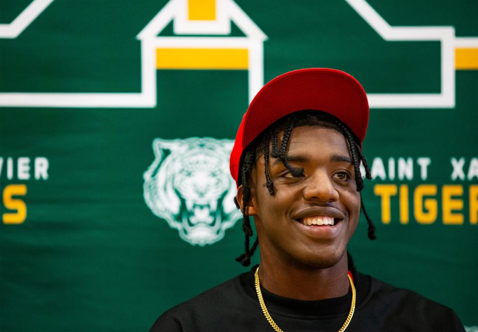 St. Xavier defensive end Micah Carter wore a smile and a U of L hat while signing his National Letter of Intent to play with the University of Louisville during a ceremony at St. Xavier high school. Dec. 21, 2021
