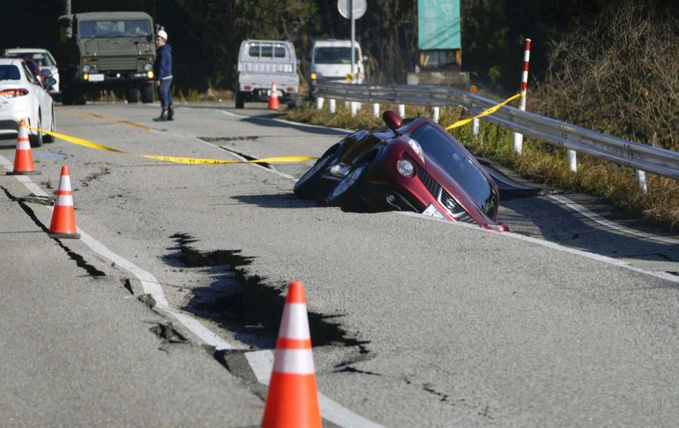 A vehicle falls into a collapsed road in Anamizumachi (AP)