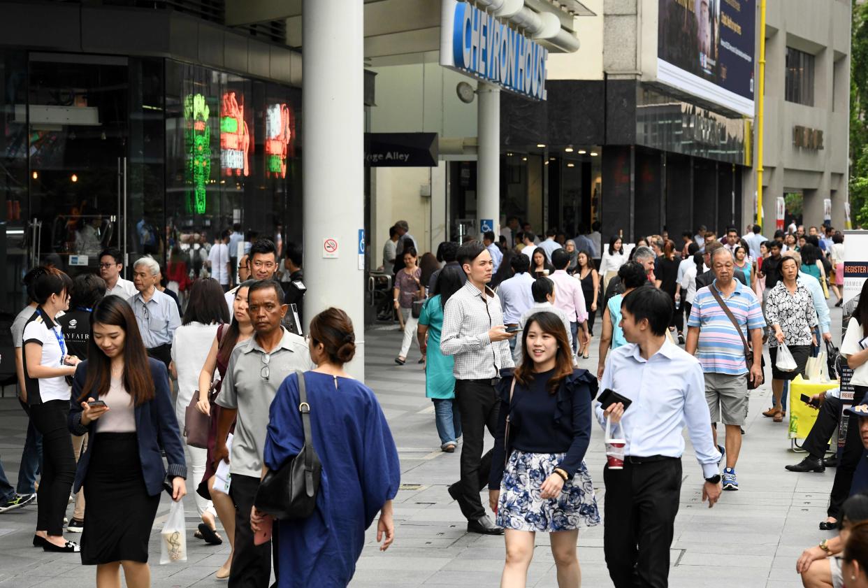 People walk along the Raffles Place business district on 5 September, 2018. (AFP file photo)