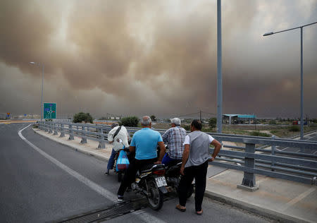 People look at smoke as a wildfire burns in Kineta, near Athens, Greece, July 23, 2018. REUTERS/Alkis Konstantinidis