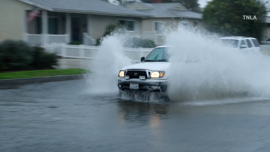 A truck drives on a flooded road in Ventura County