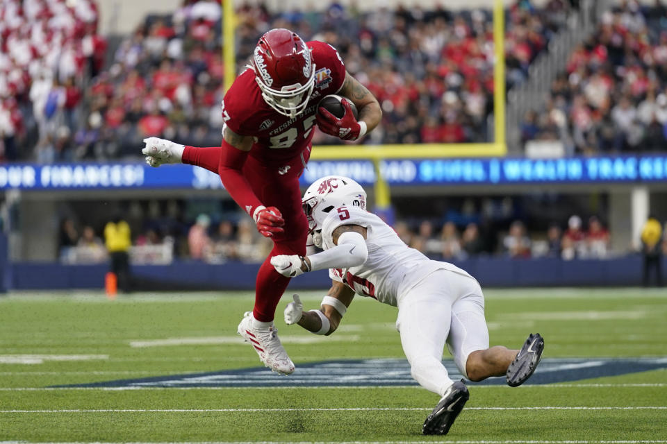 Fresno State tight end Raymond Pauwels (87) jumps over Washington State defensive back Derrick Langford Jr. (5) during the first half of the LA Bowl in Inglewood, Calif., Saturday, Dec. 17, 2022. (AP Photo/Ashley Landis)