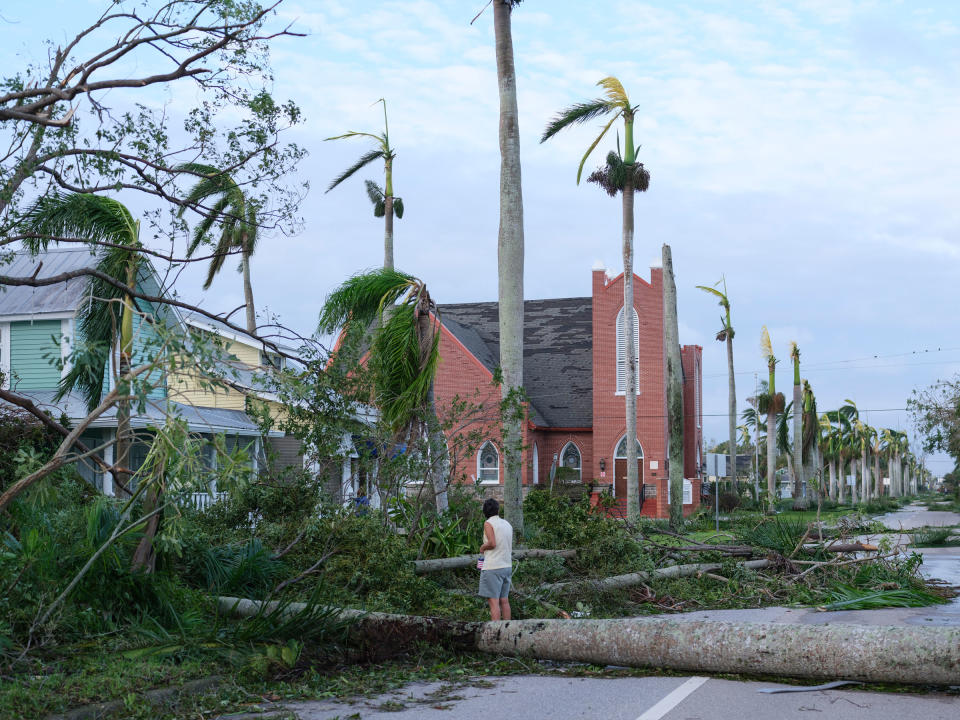 Residents emerge at dawn on Sept. 29, 2022, in downtown Crow Gables, Fla., where trees along the street were toppled by Hurricane Ian.<span class="copyright">Christopher Morris for TIME</span>