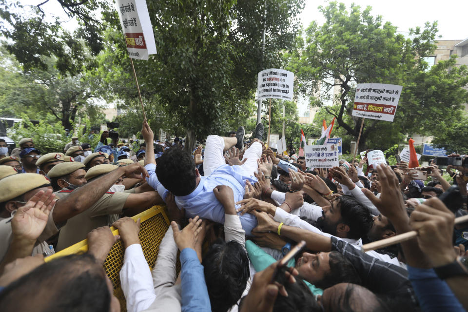 Congress party workers help their leader cross over a police barricade during a protest accusing Prime Minister Narendra Modi’s government of using military-grade spyware to monitor political opponents, journalists and activists in New Delhi, India, Tuesday, July 20, 2021. The protests came after an investigation by a global media consortium was published on Sunday. Based on leaked targeting data, the findings provided evidence that the spyware from Israel-based NSO Group, the world’s most infamous hacker-for-hire company, was used to allegedly infiltrate devices belonging to a range of targets, including journalists, activists and political opponents in 50 countries. (AP Photo/Manish Swarup)