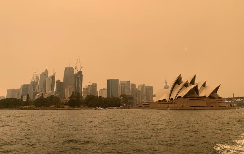 FILE PHOTO: The haze from bushfires obscures the sun setting above the Sydney Opera House in Sydney