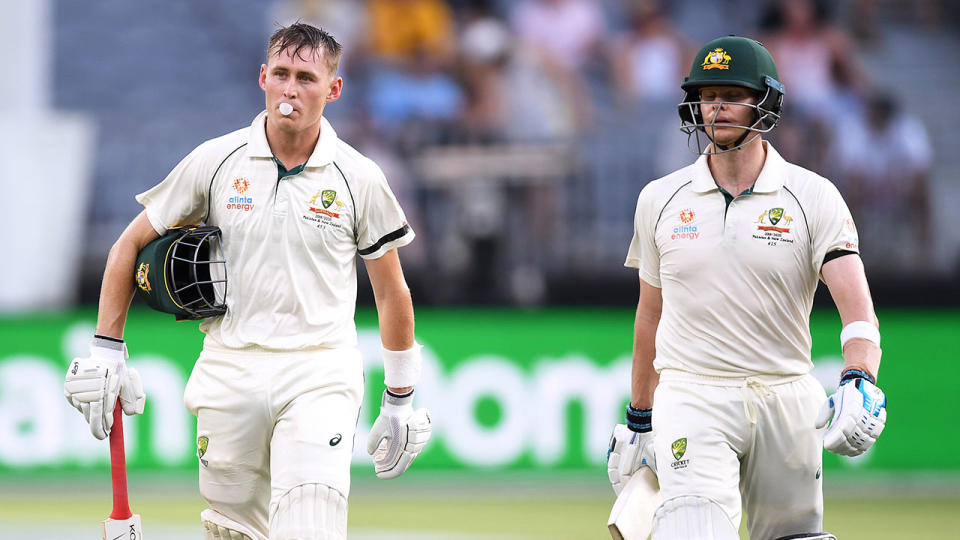 Marnus Labuschagne chews on some gum on his way back to the pavilion with Steve Smith.