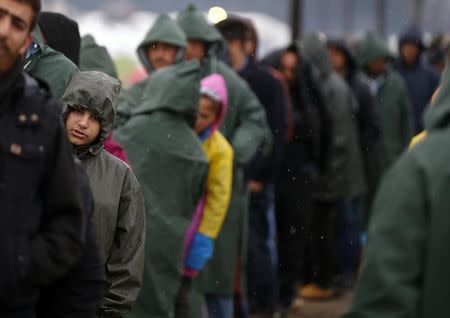 Migrants, who are waiting to cross the Greek-Macedonian border, line up for food at a makeshift camp near the village of Idomeni, Greece March 9, 2016. REUTERS/Stoyan Nenov