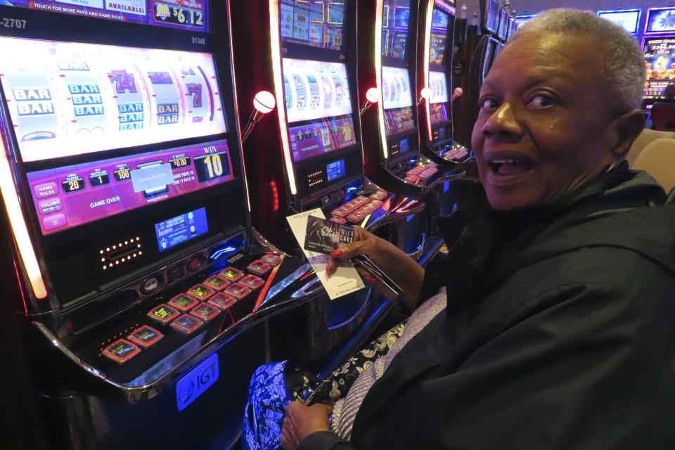 A gambler adds money to a slot machine at the Hard Rock casino in Atlantic City NJ on Aug. 8, 2022. Figures released on Feb. 15, 2023 by the American Gaming Association show the U.S. commercial casino industry won over $60 billion from gamblers in 2022, its best year ever. (AP Photo/Wayne Parry)