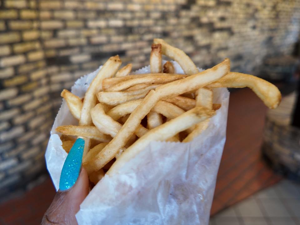 hand holding up a bag of kopps french fries