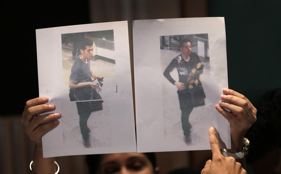 Pictures of the two men, a 19-year old Iranian, identified by Malaysian police as Pouria Nour Mohammad Mehrdad, left, and the man on the right, his identity still not released, who boarded the now missing Malaysia Airlines jet MH370 with stolen passports, is held up by a Malaysian policewoman during a press conference, Tuesday, March 11, 2014 in Sepang, Malaysia. One of the two men traveling on a missing Malaysian Airlines jetliner was an Iranian asylum seeker, officials said Tuesday, as baffled authorities expanded their search for the Boeing 777 on the opposite side of the country from where it disappeared nearly four days ago with 239 people on board.(AP Photo/Wong Maye-E)