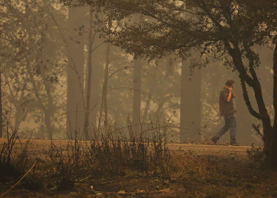 Pictured is a man walking through burnt land. 