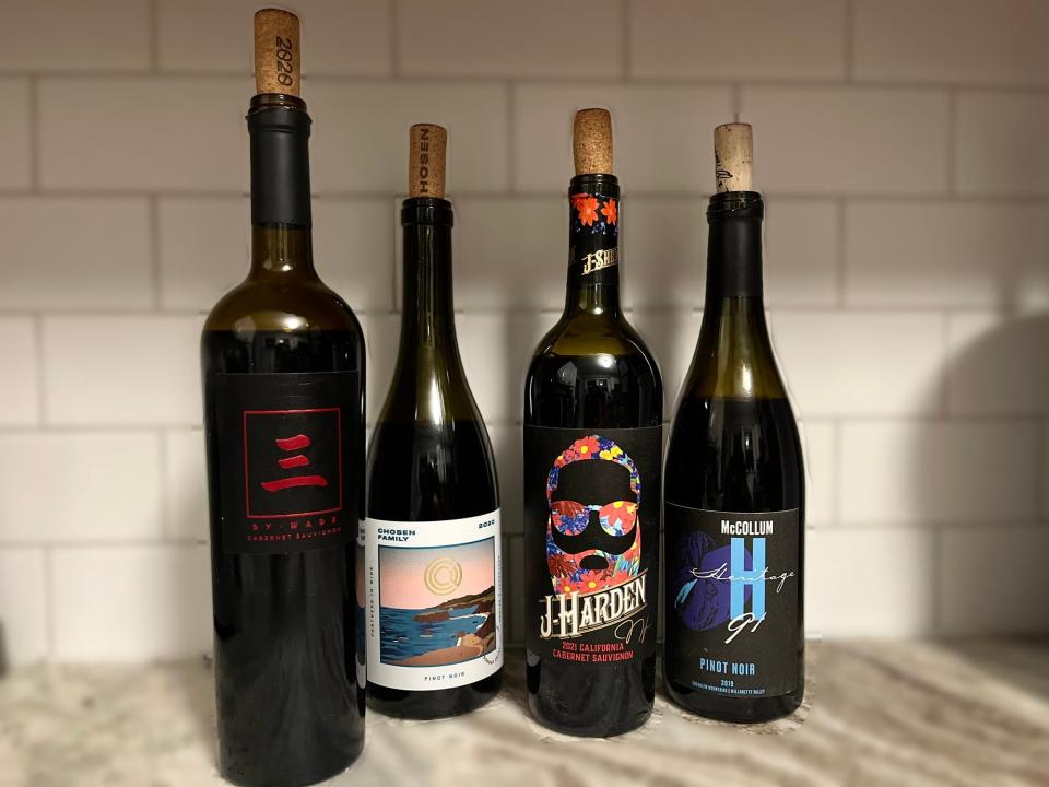 Four bottles of wine sit next to each other on a counter.