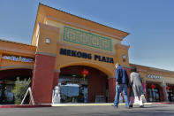 In this Feb. 13, 2020, photo, patrons enter Mekong Plaza in the Asian district, in Mesa, Ariz. Arizona's freshly crowned Asian District was deep into organizing its night market when news broke that a case of the illness known as COVID-19 was confirmed at nearby Arizona State University. Xenophobic comments on social media and phone calls started almost immediately, according to Arizona Asian Chamber of Commerce CEO Vicente Reid. (AP Photo/Matt York)