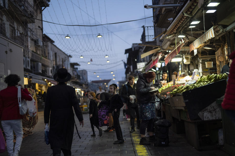 A woman buys fruits at a shop in the Mahane Yehuda market in Jerusalem, Sunday, April 14, 2024. Israel on Sunday hailed its air defenses in the face of an unprecedented attack by Iran, saying the systems thwarted 99% of the more than 300 drones and missiles launched toward its territory. (AP Photo/Leo Correa)