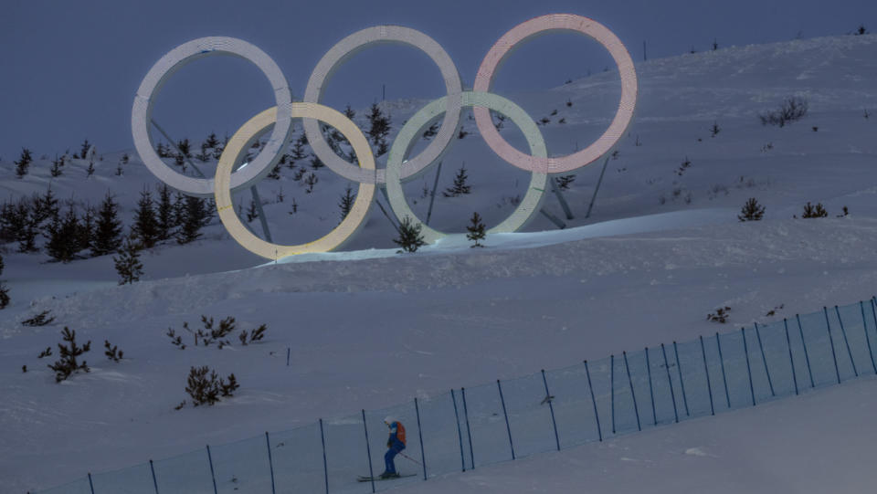 A worker skis past Olympic Rings at a slope in Genting Snow Park on February 1, 2022 in Zhangjiakou, China.