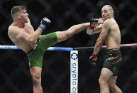 Sean Strickland, right, ties to avoid a kick from Dricus Du Plessis during a middleweight title mixed martial arts bout at UFC 297 in Toronto early Sunday, Jan. 21, 2024. (Nathan Denette/The Canadian Press via AP)