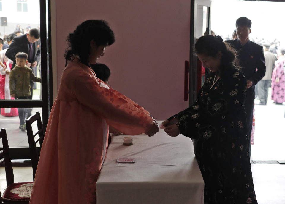 A woman receives a ballot from an electoral worker before giving her vote during the election at a polling station in Pyongyang, North Korea, Sunday, March 10, 2019. Millions of North Korean voters, including leader Kim Jong Un, are going to the polls to elect roughly 700 members to the national legislature. In typical North Korean style, voters are presented with just one state-sanctioned candidate per district and they cast ballots to show their approval or, very rarely, disapproval. (AP Photo/Dita Alangkara)