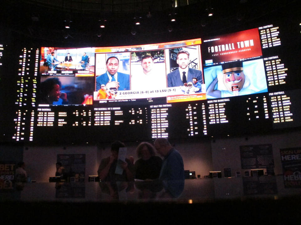 FILE - In this Oct. 12, 2018, file photo, people sit inside a sports betting lounge at the Ocean Resort Casino in Atlantic City N.J. Now, for the first time in the United States, you can legally bet on one of pop culture’s biggest nights. New Jersey is the first state in the U.S. to allow sportsbooks to accept wagers on the Oscars, taking after a common practice in Europe and giving American fans another option besides informal office pools. (AP Photo/Wayne Parry, File)