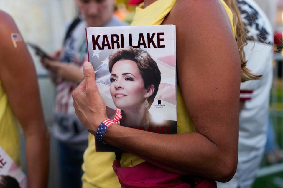 A book cover showing former Arizona gubernatorial candidate Kari Lake is held and waiting to be signed as Lake autographs books before the start of a campaign rally for former President Donald Trump in Hialeah, Fla., Wednesday, Nov. 8, 2023. (AP Photo/Lynne Sladky)