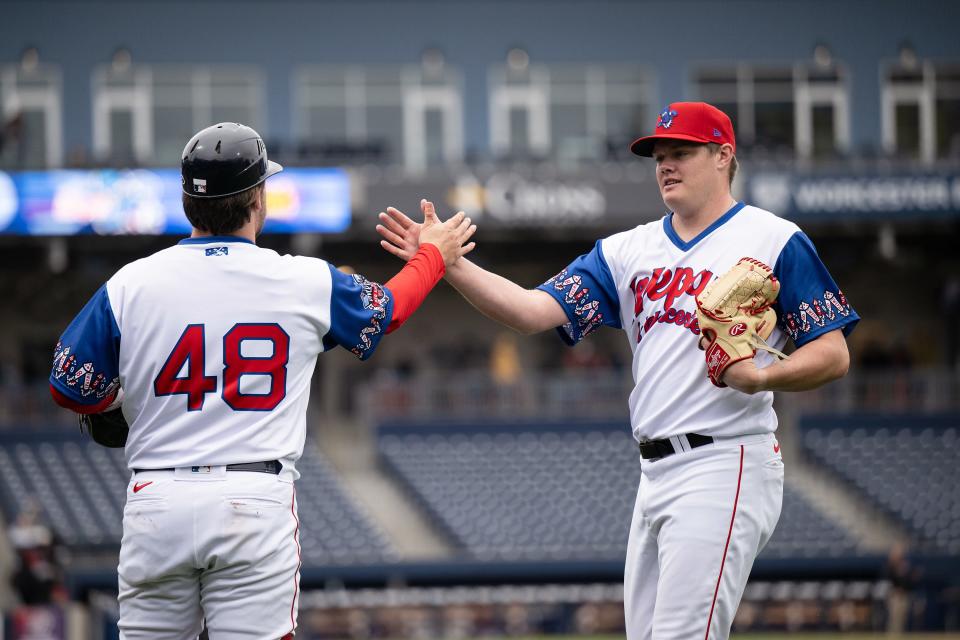 WooSox pitcher Richard Fitts, right, high fives catcher Nathan Hickey after warming up to face the Lehigh Valley IronPigs on Tuesday.