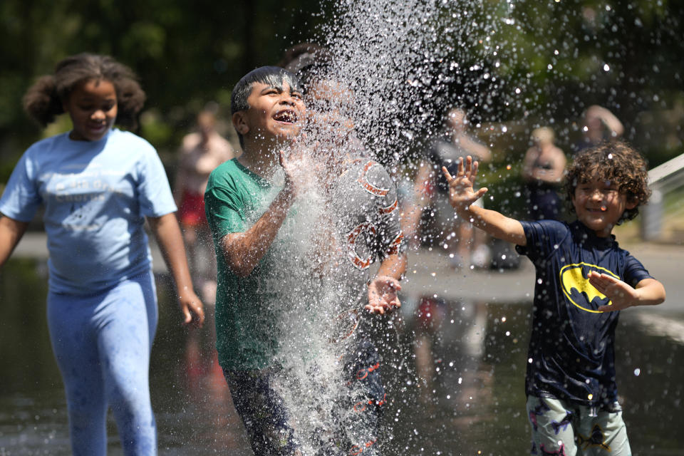 Kids enjoy a water spout at Crown Fountain in Chicago's Millennium Park as temperatures climbed into the 90s Fahrenheit, Friday, June 2, 2023, in Chicago. (AP Photo/Charles Rex Arbogast)