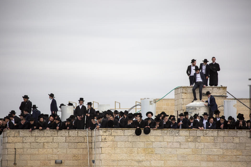 Ultra-Orthodox Jews participate in the funeral for prominent rabbi Meshulam Soloveitchik, in Jerusalem, Sunday, Jan. 31, 2021. The mass ceremony took place despite the country's health regulations banning large public gatherings, during a nationwide lockdown to curb the spread of the coronavirus. (AP Photo/Ariel Schalit)