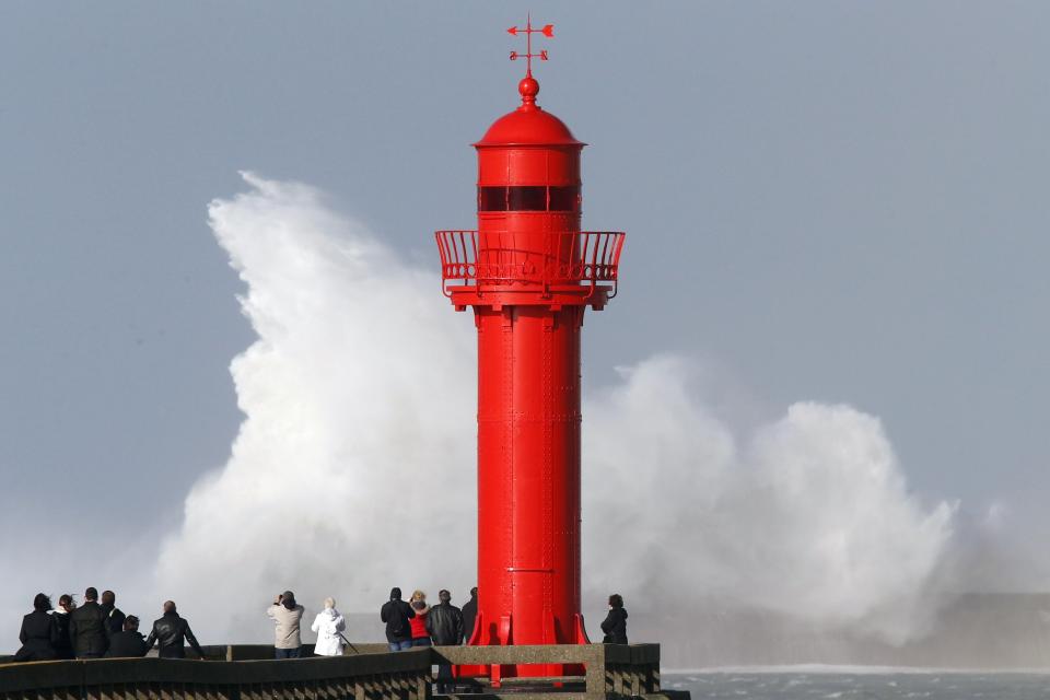 People look at waves crashing against a pier during a storm named Christian that battered France at Boulogne sur Mer northern France October 28, 2013. (REUTERS/Pascal Rossignol)