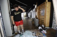 Nike store employee Enrique Barajas stands on a window display of the looted store Monday, June 1, 2020, in Santa Monica, Calif., a day after unrest and protests over the death of George Floyd, a black man who was in police custody in Minneapolis. Floyd died after being restrained by Minneapolis police officers on May 25. (AP Photo/Marcio Jose Sanchez)