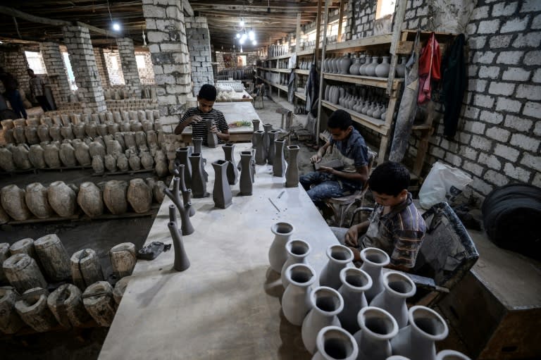 Employees at Mostafa el-Agoury's pottery factory work on vases at Agoury's workshop in Egypt's Menufiya province on June 21, 2018