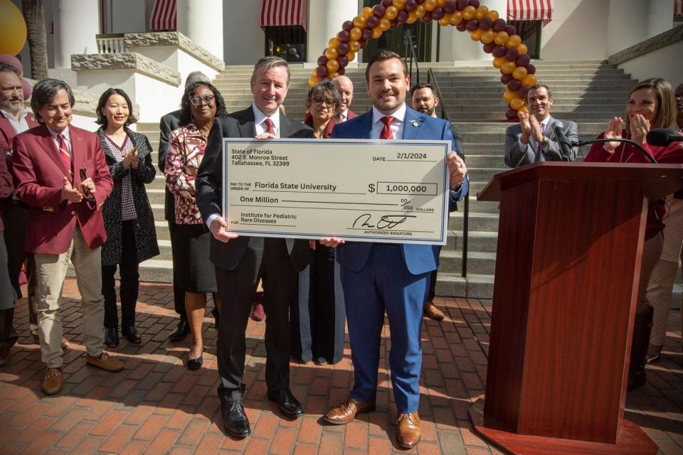 State Rep. Adam Anderson (right) holds a check with FSU President Richard McCullough (left) after holding a press conference with FSU leaders outside of the Florida State Capitol to announce the newly funded Institute for Pediatric Rare Diseases on Thursday, Feb. 1, 2024.